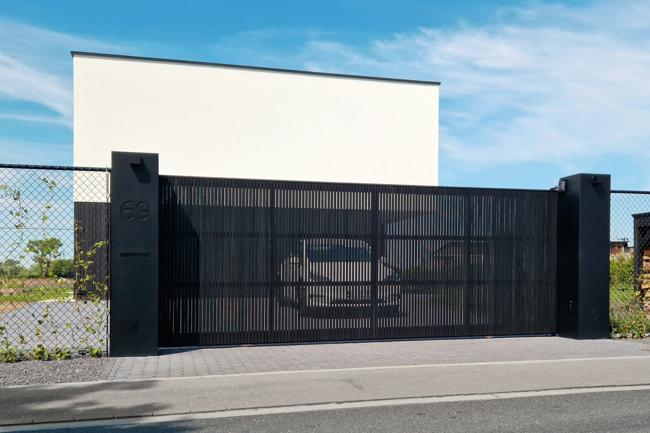 Schuifpoort op rail bekleed met gezwarte thermowood in Nazareth