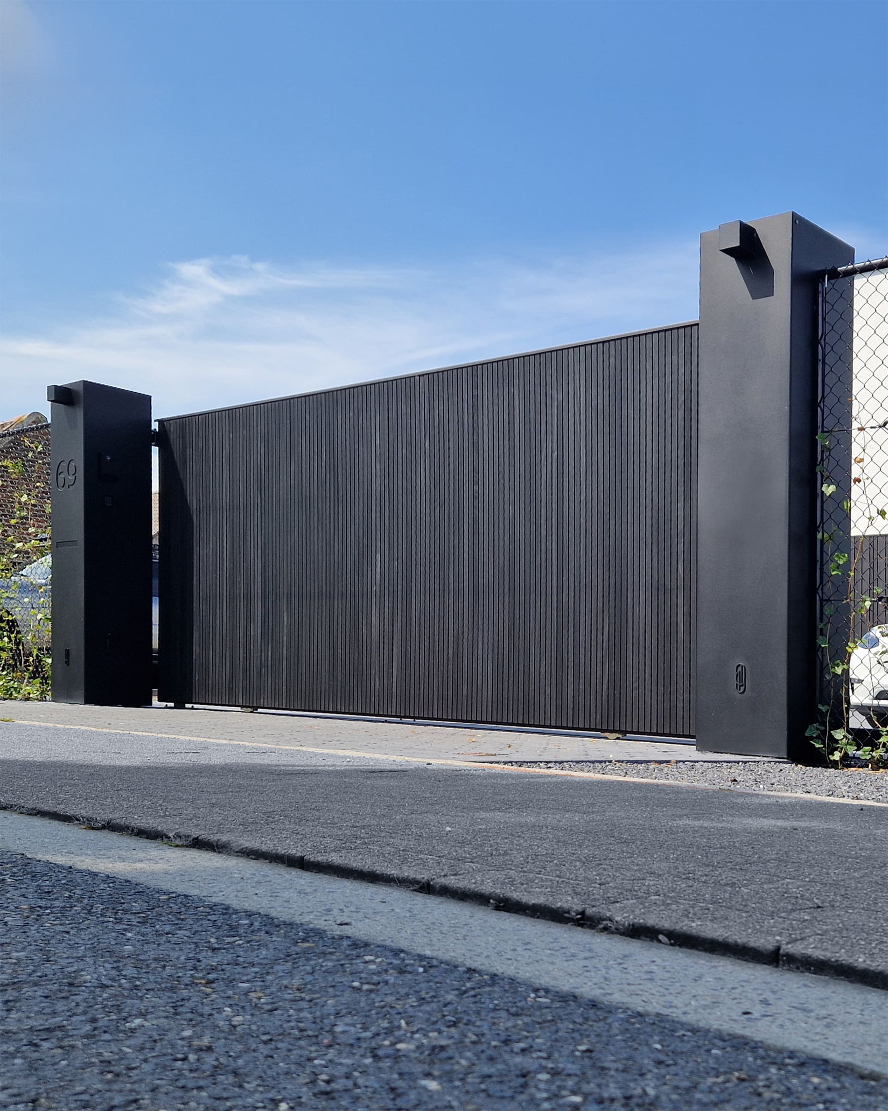 Schuifpoort op rail bekleed met gezwarte thermowood in Nazareth