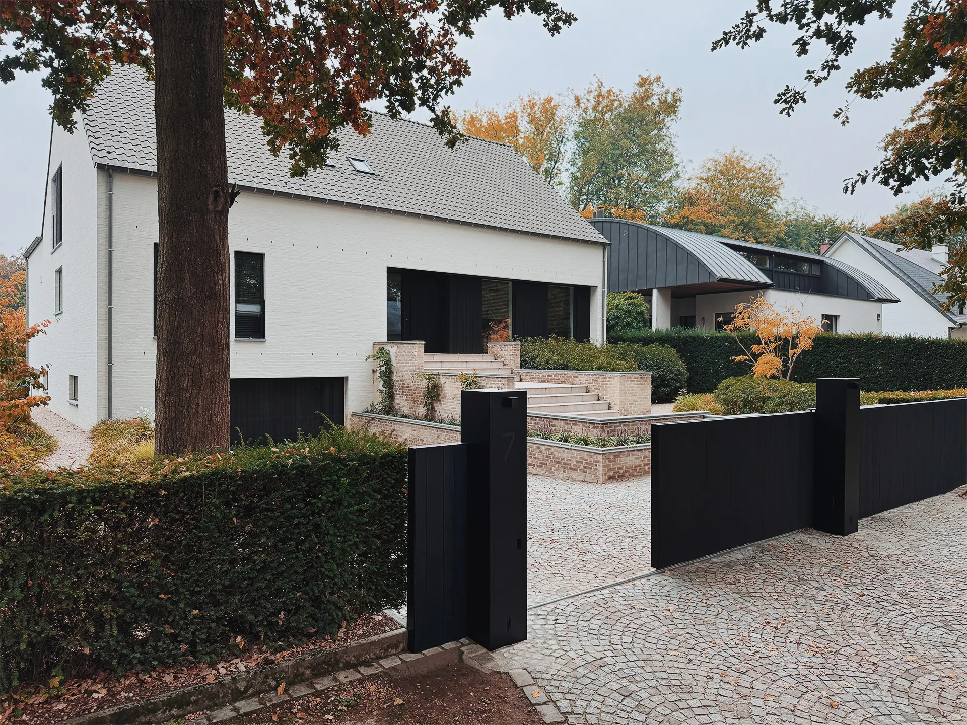 Schuifpoort met vast paneel in zwart geborsteld hout in Aalst
